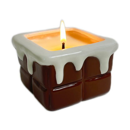 Chocolate ganache scented ceramic soy candle with a glossy drip-style design, lit and photographed on a white background.